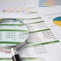 Magnifying glass on charts graphs paper Financial development Magnifying glass on charts graphs paper. Financial development, Banking Account, Statistics, Investment Analytic research data economy, Stock exchange trading, Business office company meeting concept.